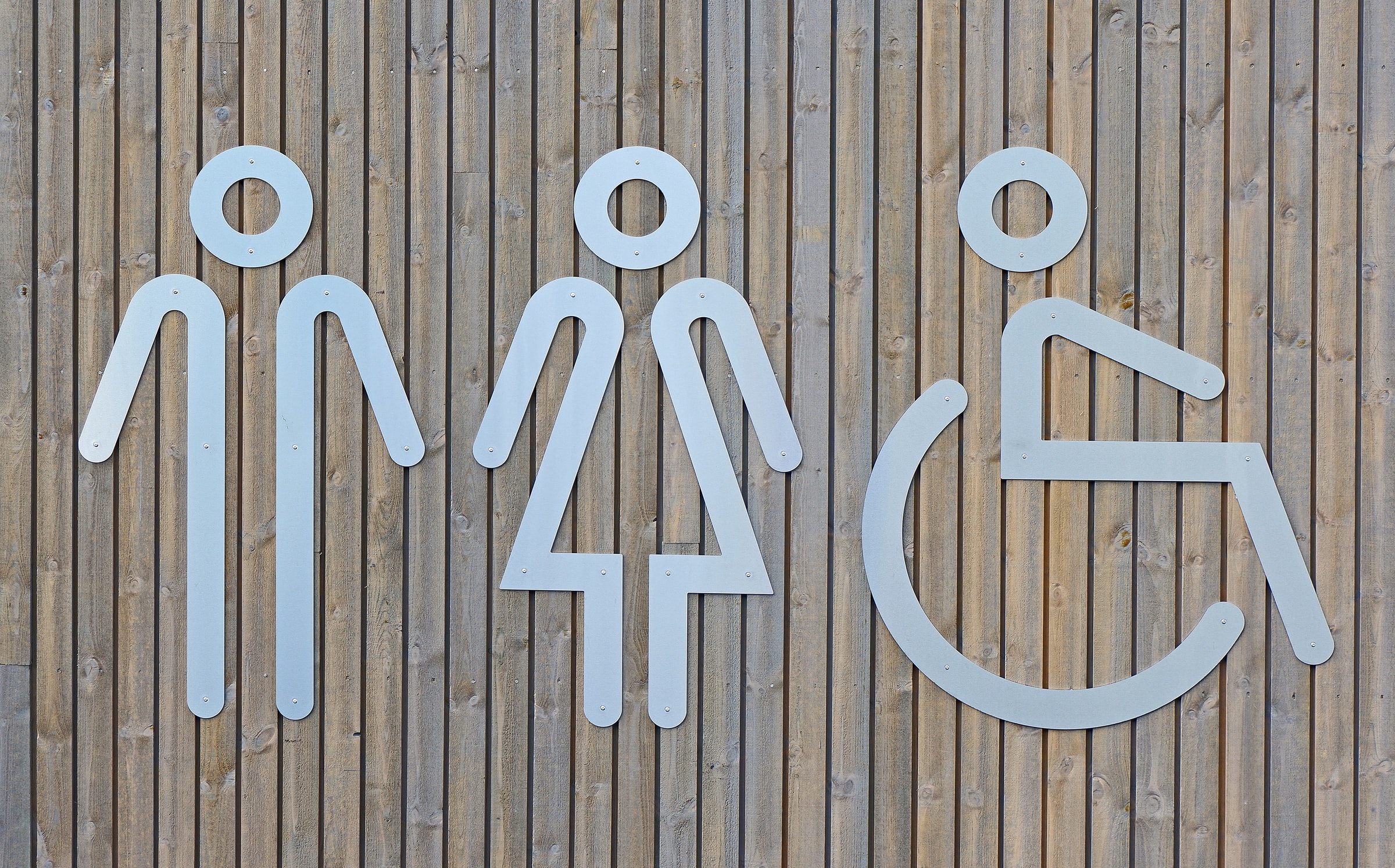 Three symbols for people, representing 'male', 'female' and 'wheelchair user'