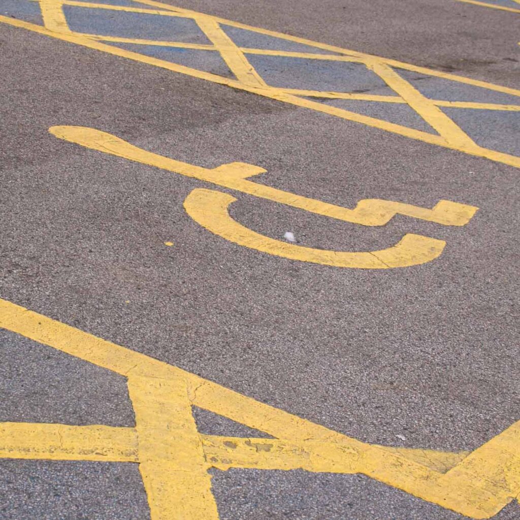 An empty Blue Badge parking space shows the yellow wheelchair icon associated with disability