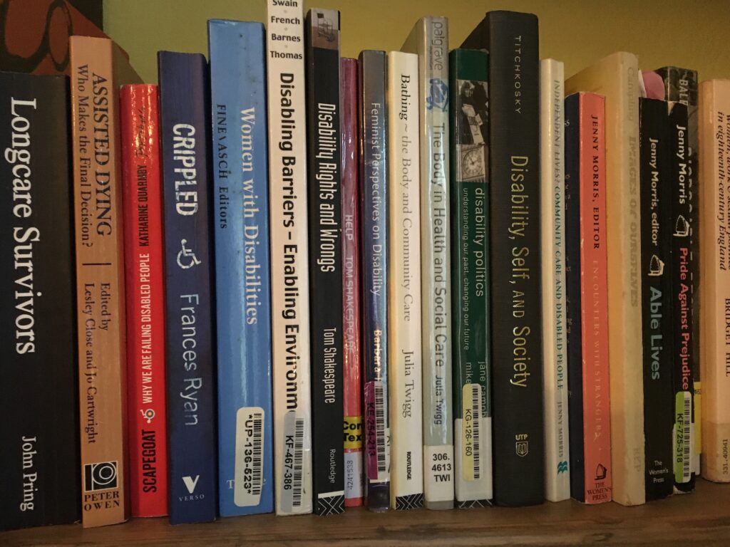 A row of books on a shelf, all on the topic of disability