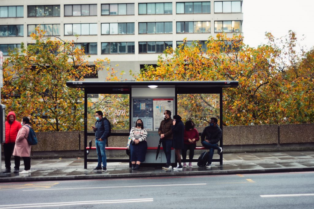 Several people waiting at a bus stop