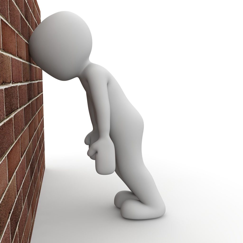 figure hitting head against brick wall