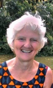 Marilyn, a white woman with short white hair, smiling at the camera.