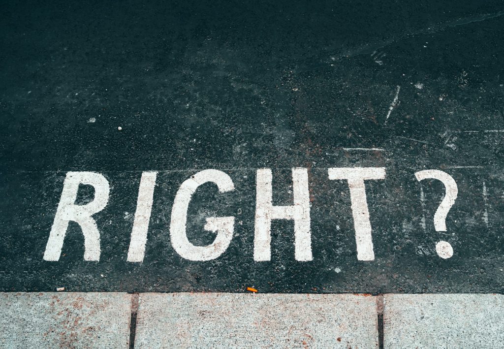 The question 'right?' written on the surface of a road
